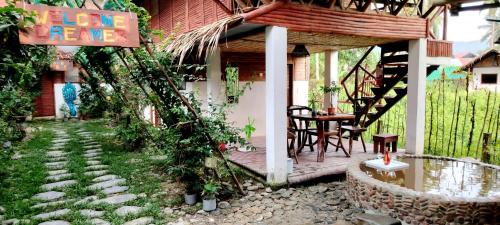 a porch of a house with a table and chairs at Dreamer Resort in San Vicente
