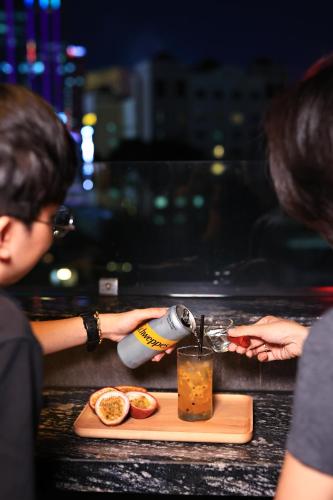 a person is making a drink at a counter at Hato Saigon Boutique Hotel & Rooftop in Ho Chi Minh City