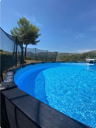une grande piscine bleue entourée d'une clôture. dans l'établissement Mon rêve - Maison Provençale Piscine, à Roquevaire