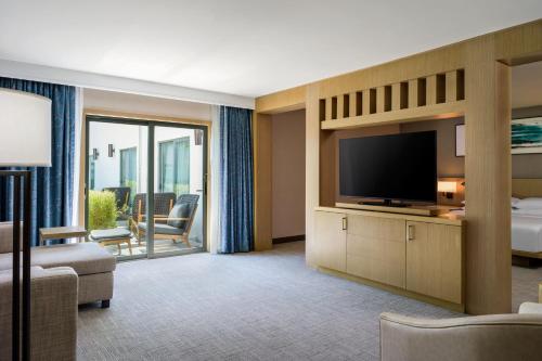 a hotel room with a bed and a flat screen tv at Delta Hotels by Marriott Ontario Airport in Ontario
