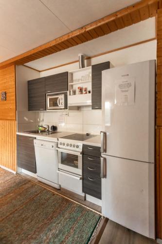 a kitchen with white appliances and a refrigerator at Motelli Rovaniemi in Rovaniemi