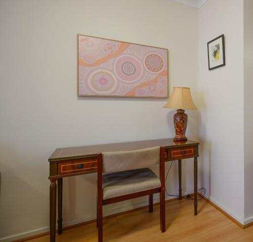 a desk with a chair and a lamp on a wall at Best Location Leederville Townhouse in Perth