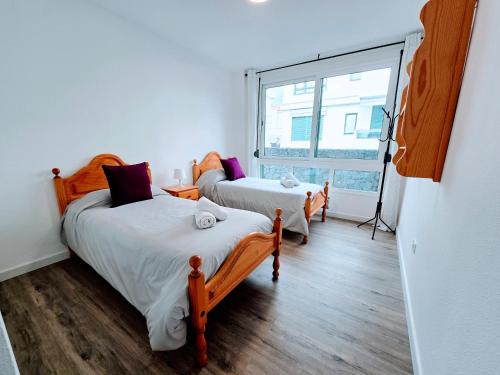 zwei Betten in einem Zimmer mit Fenster in der Unterkunft VV La Caracola "by henrypole home" in Breña Baja