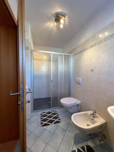 a bathroom with a toilet and a sink and a shower at Appartements Schatzer in Valdaora