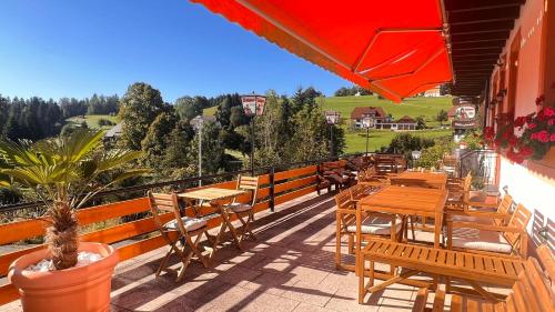a restaurant with tables and chairs on a balcony at Boutique Hotel and Apartments Pension Sternen in Todtmoos