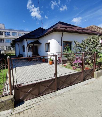 a fence in front of a white house at Casa Marina in Călimăneşti