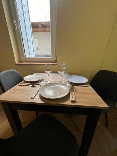 una mesa de madera con platos y vasos. en TripleA Sr apartments, en Belgrado