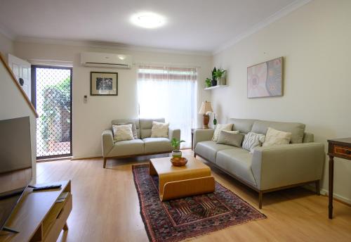 a living room with two couches and a tv at Best Location Leederville Townhouse in Perth