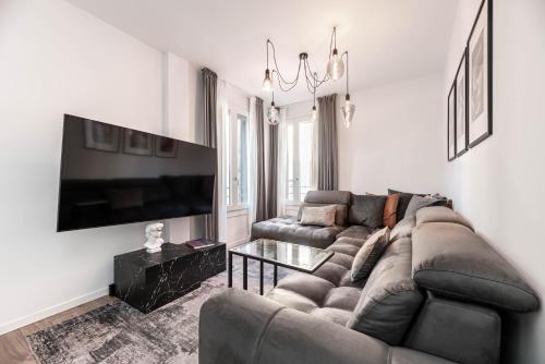 a living room with a couch and a flat screen tv at Ca' San Marco - Residenza di Lusso a Due Passi dalla Basilica in Vicenza