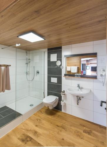 a bathroom with a shower toilet and a sink at Hotel-Restaurant Heiligenstadter Hof in Heiligenstadt