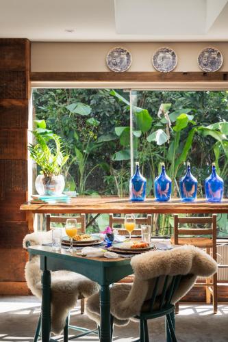 a table with glasses of orange juice and blue vases at Work Hotel Design in São Leopoldo