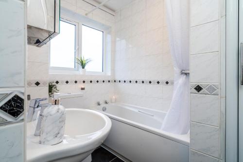 a white bathroom with a tub and a toilet at Mayflower 5-Bed Home, Contractors, Family Xmas, Harry Porter in Hemel Hempstead