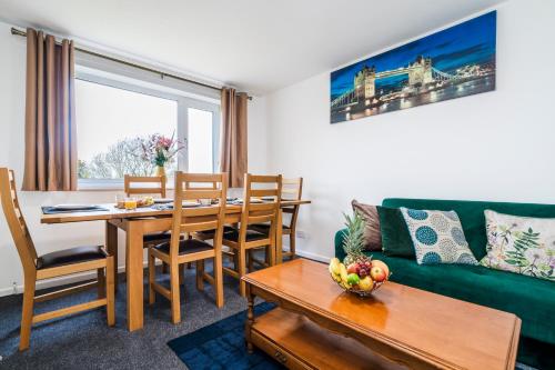 a living room with a table and a green couch at Mayflower 5-Bed Home, Contractors, Family, Harry Porter in Hemel Hempstead