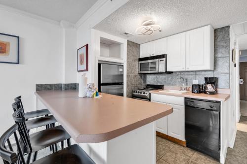 a kitchen with white cabinets and a counter top at Meridian Plaza 404 in Myrtle Beach