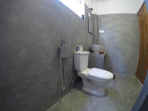 a bathroom with a toilet and a shower at Karma Guesthouse in Hikkaduwa