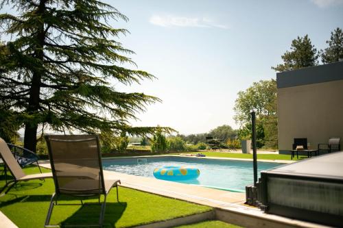 - une piscine avec une chaise et une nouille dans la cour dans l'établissement Villa Montplaisir 180m2, jacuzzi, parc de 20000m2, à Charmes-sur-Rhône