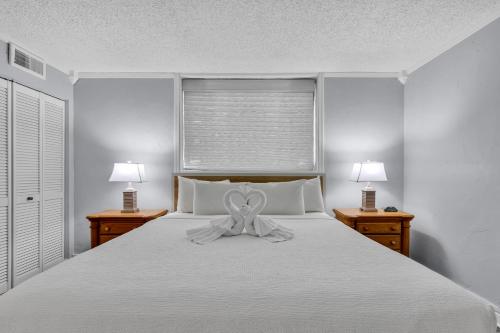 a white bed with a bow on top of it at Spectacular Oceanview Condos in Myrtle Beach