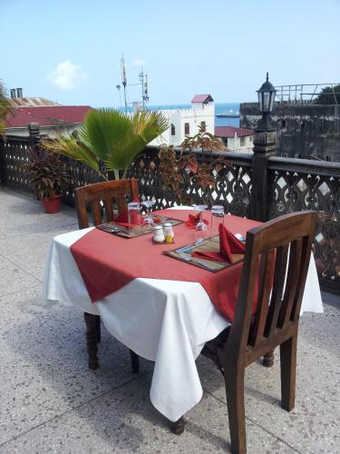 a table with a red and white table cloth on it at Asmini Palace Hotel in Zanzibar City