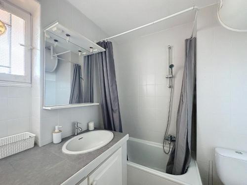 une salle de bain blanche avec un lavabo et une douche dans l'établissement Studio Bord de Mer Boulouris à Saint Raphaël, à Saint-Raphaël