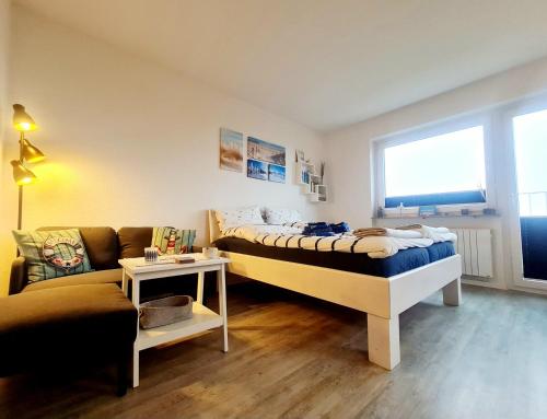 a bedroom with a large bed and a couch at Lieblingsort in Sankt Peter-Ording