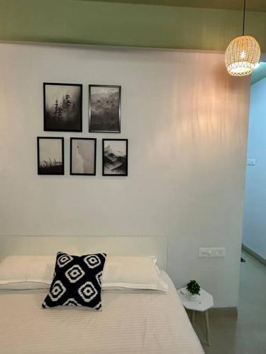 a bedroom with a bed with four pictures on the wall at Ozone Pvt Studio Apt with Balcony in Koregaon Park Near Osho Ashram in Pune