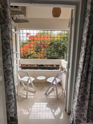 a balcony with two chairs and a table and a window at Ozone Pvt Studio Apt with Balcony in Koregaon Park Near Osho Ashram in Pune