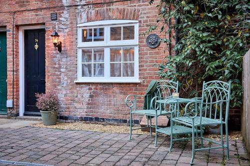 two chairs and a table in front of a building at The Knitters House - Luxury 3 Bedroom Property in Nottingham