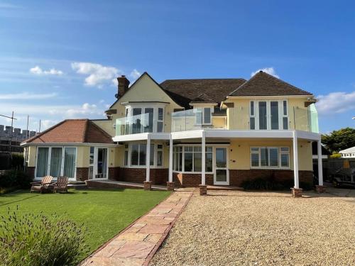 a large yellow house with a large yard at Barton on Sea self contained, stunning sea views in Barton on Sea