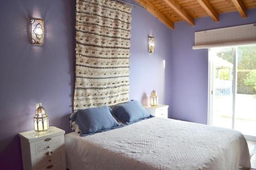 a bedroom with purple walls and a bed with blue pillows at Wanderlust - Beautiful Villa in Aljezur in Aljezur