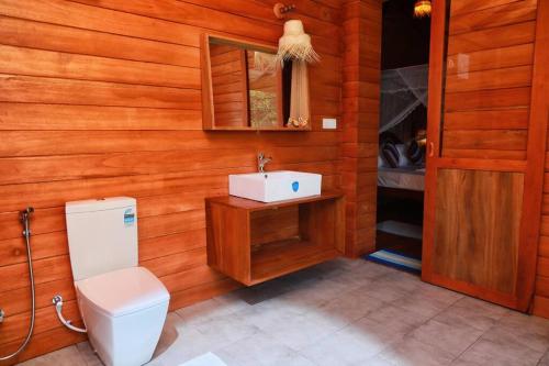 a bathroom with a toilet and a sink at Oasis cabanas in Hikkaduwa