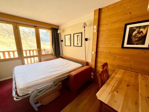 une chambre avec un lit et une table dedans dans l'établissement NOUVEAU à BELLE PLAGNE - Pieds des pistes et ESF !, à Belle Plagne