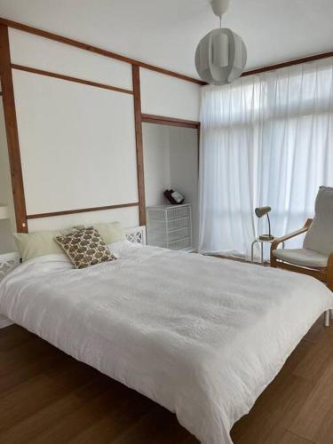a bedroom with a large white bed and a chair at Stay&Explore Okuma,Yanbaru National Park,Cape Hedo in Kunigami