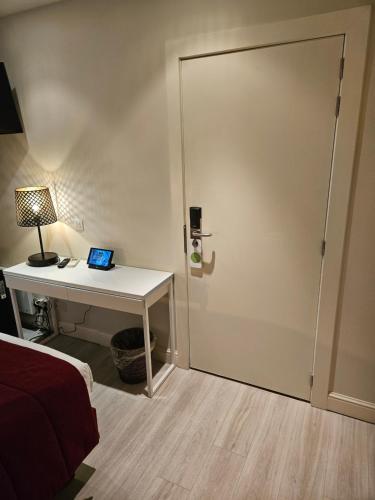 a bedroom with a desk and a door with a laptop at Hotel Acacia in Bruges