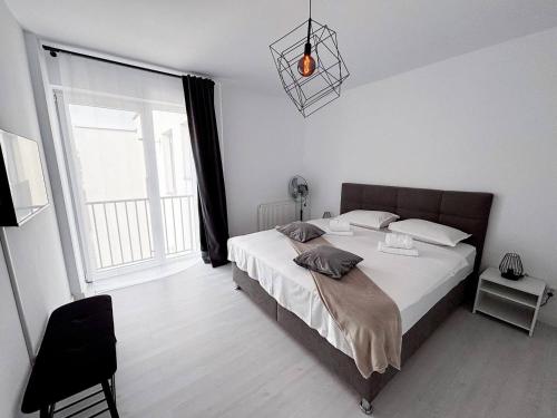 Un dormitorio con una cama y una ventana grande. en Wonder Apartment With Terrace, en Cluj-Napoca
