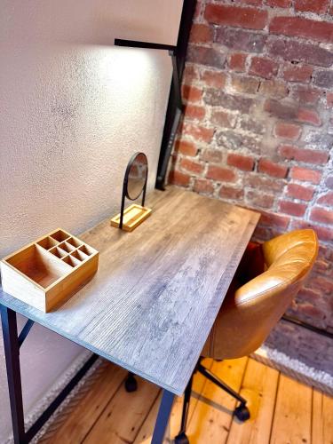 a wooden table with a mirror and a chair at Suburban Loft in Bochum