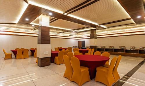 a conference room with tables and yellow chairs in it at Hotel Chandigarh Grand and Banquet in Manī Mājra