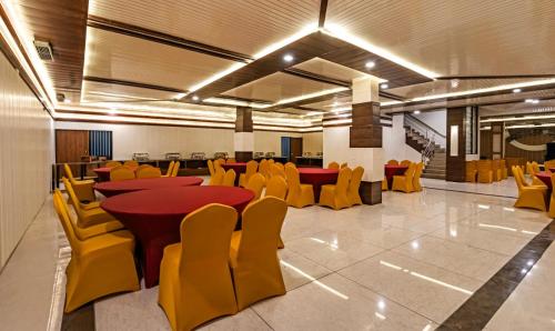 a conference room with yellow chairs and red tables and chairs at Hotel Chandigarh Grand and Banquet in Manī Mājra