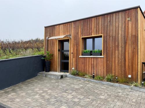 a wooden house with two windows and a patio at Suite LIANA - SPA- SAUNA in Rorschwihr