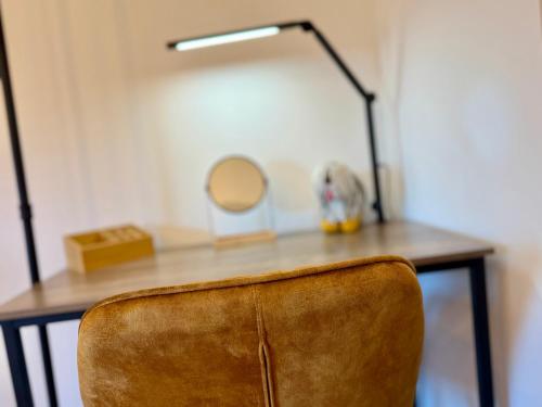 a desk with a mirror and a brown chair at Suburban Loft in Bochum