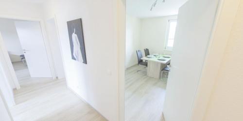 Habitación blanca con espejo y escritorio. en Eifellounge, en Monschau