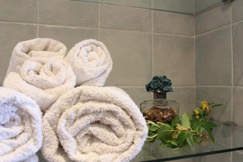 a pile of towels on a shelf in a bathroom at Apartamentos Casa Germana in Tapia de Casariego