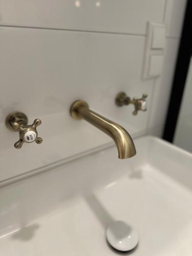 a bathroom sink with a gold faucet on it at Allerhaus Apartments am Ackerbürgerhaus in Verden