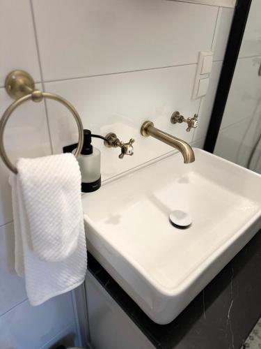 a white sink in a bathroom with a towel at Allerhaus Apartments am Ackerbürgerhaus in Verden