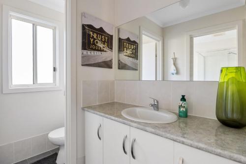 a bathroom with a sink and a toilet and mirrors at Valley Views - 11 Woodgate Road in Second Valley