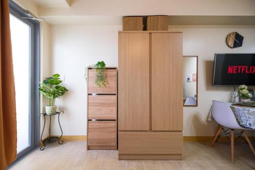 a tall wooden cabinet in a room with a desk at Skyline Stay in Manhattan in Manila