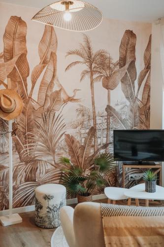 - un salon orné d'une fresque murale représentant des palmiers dans l'établissement -Les Petits Ga!llards- 3 Studios à Thèmes, à Brive-la-Gaillarde