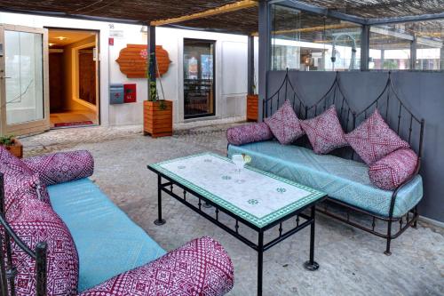 a patio with two couches and a coffee table at Casa da Praça Guest House in Sesimbra