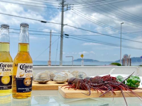 two bottles of beer and a lobster on a table at OCEAN FRONT TATEYAMA - Vacation STAY 35718v in Tateyama