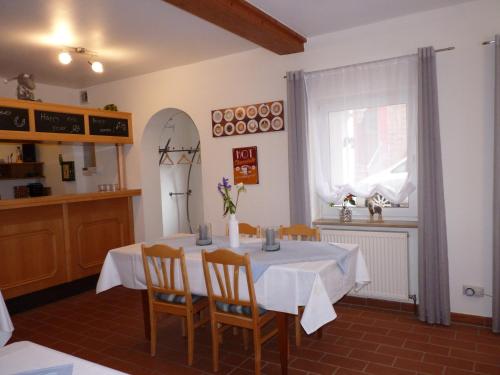 ein Esszimmer mit einem Tisch, Stühlen und einem Fenster in der Unterkunft Gästehaus Bacchus in Wachenheim an der Weinstraße