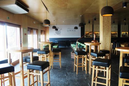 a bar with stools and tables in a room at Casa da Urra in Urra